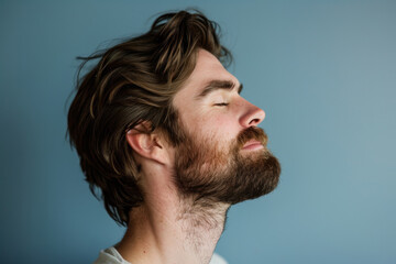 Obraz premium A close up of a man with beard and closed eyes looking to a side