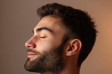 Obraz premium A close up of a man with beard and closed eyes looking to a side