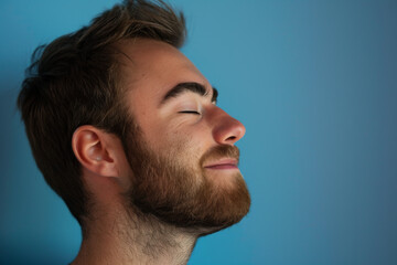 Fototapeta premium A close up of a man with beard and closed eyes looking to a side