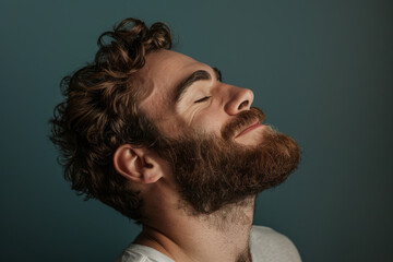 Obraz premium A close up of a man with beard and closed eyes looking to a side