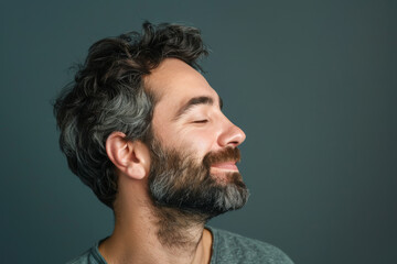 Fototapeta premium A close up of a man with beard and closed eyes looking to a side