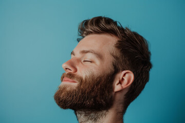 Obraz premium A close up of a man with beard and closed eyes looking to a side