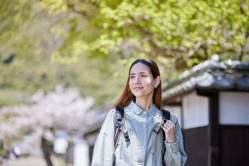 春の観光地を歩くインバウンド旅行者の女性