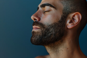 Obraz premium A close up of a man with beard and closed eyes looking to a side