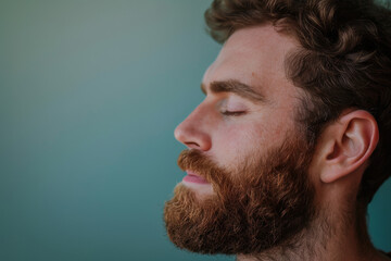 Obraz premium A close up of a man with beard and closed eyes looking to a side