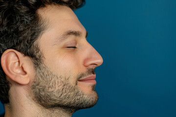 Obraz premium A close up of a man with beard and closed eyes looking to a side