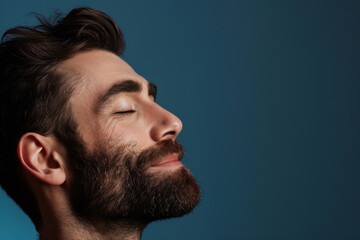 Fototapeta premium A close up of a man with beard and closed eyes looking to a side