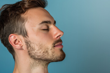 Obraz premium A close up of a man with beard and closed eyes looking to a side