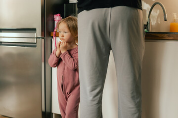 Close-up of a girl near her father in the kitchen. The concept of genderblend and role reversal in...