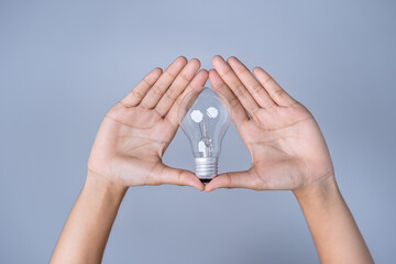 Close-up of both women's hands Holding a light bulb, innovative technology in science and...