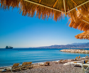 Sunny morning on sandy beach of the Red Sea in Eilat - famous tourist resort and recreational city...