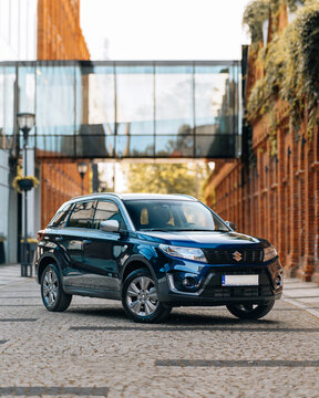 Photo of a blue Suzuki Vitara. They show details of the car from the outside. In an industrial site. The photo is suitable for use in marketing materials, advertisements or press articles.