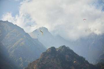 The sport of paragliding. Parachuting over high mountains. Beautiful natural landscape.