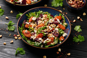 Warm baked carrots and beetroot salad with feta cheese and roasted hazelnuts