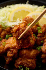 Japanese Fried crispy Chicken Karaage in black bowl with rice and cabbage