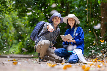 Asian biologist team is collecting data in forest field study of mud puddling phenomenon...