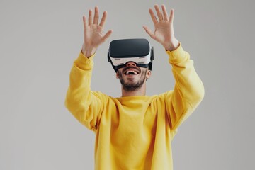 Naklejka premium A man wearing VR glasses is smiling and standing with his hands raised