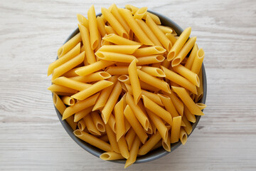 Raw Organic Dry Penne Pasta in a Bowl, top view. Overhead, flat lay, from above.