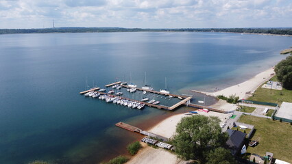 Widok z góry nad marinę dok i przycumowane łódki żaglówki jachty na wodzie jeziorze