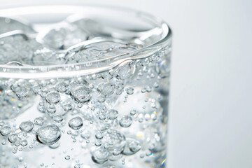 Macro Close-Up of Sparkling Water Surface in Glass on Bright White Background, Product Advertisement, Minimalist and Clean Design, Effervescent Bubbles, Freshness, and Pure Beverage Focus