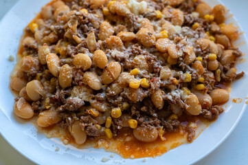 A plate of food with beans, corn, and cheese