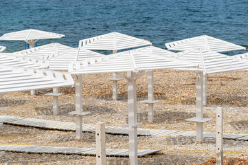 Sea beach with sand and row of wooden umbrellas