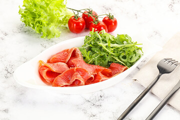 Sliced salmon with fresh arugula