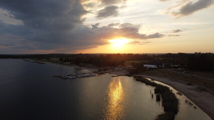 Obraz premium Sunset over the lake water with marina with boats sailboats yachts