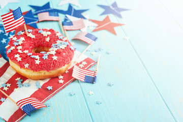 Obraz premium Patriotic sweet donuts 4th july with american flag. Delicious american donuts with red icing and blue and red stars toping on blue background. Dessert food for American Independence Day celebration.
