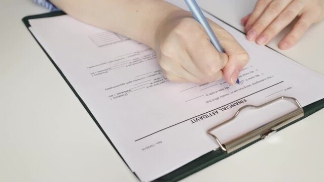 Financial affidavit, hand fills out a document, corporate agreement, banking