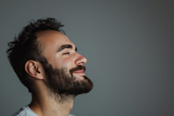Obraz premium A close up of a man with beard and closed eyes looking to a side