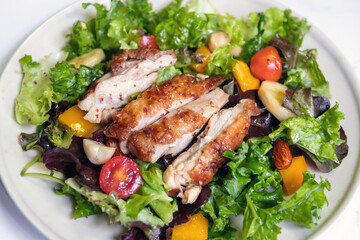 Salad with grilled chicken, cherry tomatoes, lettuce, cucumber and nuts