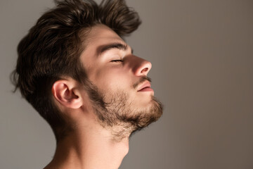 Obraz premium A close up of a man with beard and closed eyes looking to a side