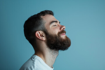 Obraz premium A close up of a man with beard and closed eyes looking to a side