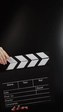 Hands with clapper board, cueing the action, movie production in progress.