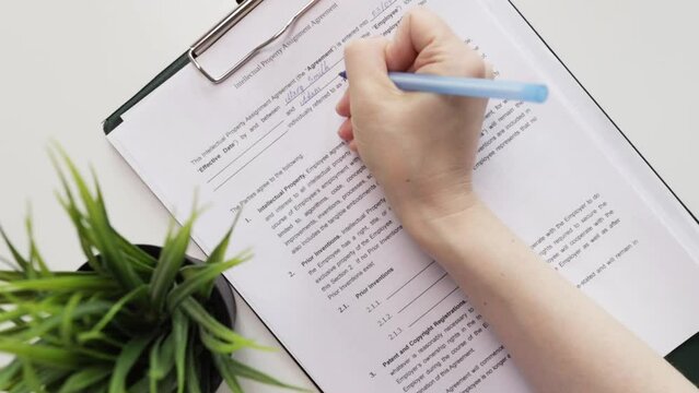 Intellectual property assignment agreement, hand fills out a document, trademark contract, brand authorization, business security