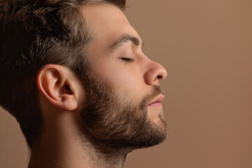 Obraz premium A close up of a man with beard and closed eyes looking to a side