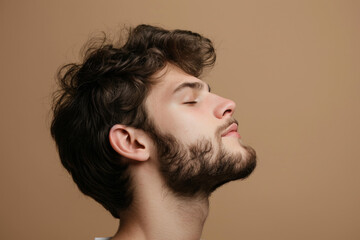 Fototapeta premium A close up of a man with beard and closed eyes looking to a side