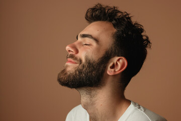 Obraz premium A close up of a man with beard and closed eyes looking to a side