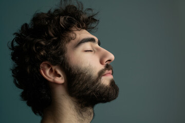 Obraz premium A close up of a man with beard and closed eyes looking to a side