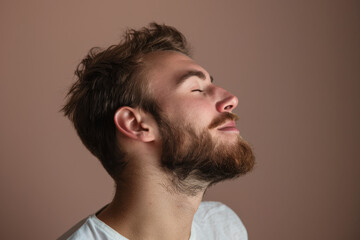 Fototapeta premium A close up of a man with beard and closed eyes looking to a side