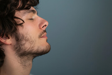 Obraz premium A close up of a man with beard and closed eyes looking to a side