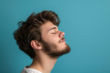 Obraz premium A close up of a man with beard and closed eyes looking to a side