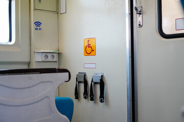 Labels for places of symbols for disabled people and locks for safe wheelchairs with seat belts in trains