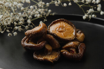 Marinated shiitake mushrooms on a black plate