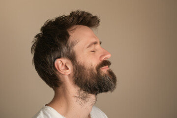 Fototapeta premium A close up of a man with beard and closed eyes looking to a side