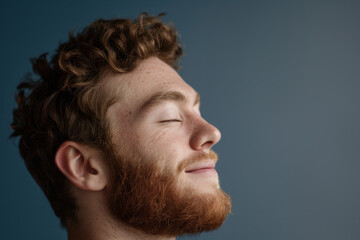 Fototapeta premium A close up of a man with beard and closed eyes looking to a side