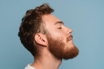 Fototapeta premium A close up of a man with beard and closed eyes looking to a side