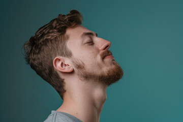 Fototapeta premium A close up of a man with beard and closed eyes looking to a side