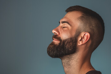 Obraz premium A close up of a man with beard and closed eyes looking to a side